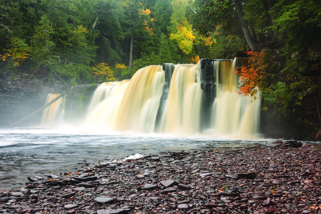Manabezho Falls on the Presque Isle River in the Upper Peninsula of Michigan surrounded by autumn colors on a misty morning (ID 96698993 © Craig Sterken | Dreamstime.com)