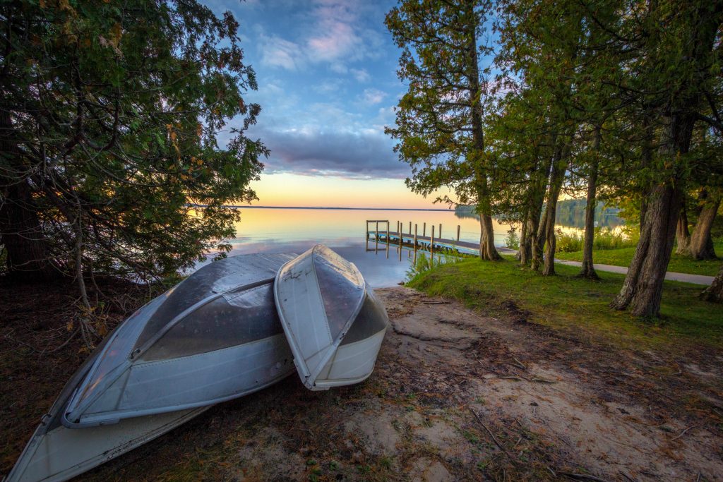 Sunset With Rowboats On Northern Michigan Lake. Rowboats On Sunset Lake. Group of aluminum rowboats on the beach of a sunset lake with a wooden dock in the background. Indian Lake State Park, Manistique, Michigan, USA. ID 214251467 © Ehrlif | Dreamstime.com