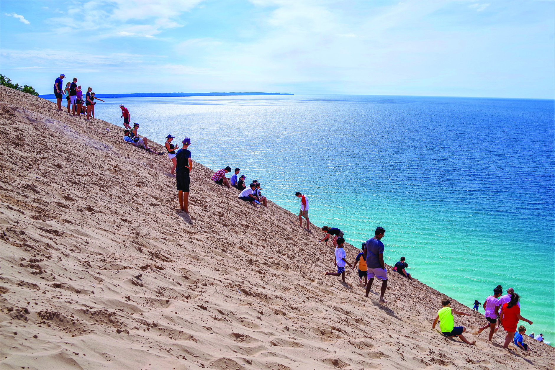 What A Grand View Across Lake Michigan. Public grouping on a steep sand dune overlook on shore of Lake Michigan at Sleeping Bear Dunes National Park on a sunny summer day with a blue sky and a vast view in Michigan, USA in August. (ID 190447459 © Schneidersimages | Dreamstime.com)